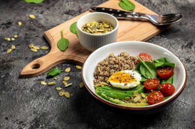 İçinde avokado, yumurta, domates, ıspanak ve ay çekirdeği olan kinoa budha kasesi. Ev yapımı yemek. Sağlıklı, temiz yemek. Vegan ya da glütensiz diyet, metin yeri, üst görünüm,