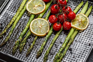 Limon ve kiraz domatesli yeşil kuşkonmaz sapları, sağlıklı yiyecekler, diyet menüsü. afiş, menü, metin için tarif yeri, üst görünüm,