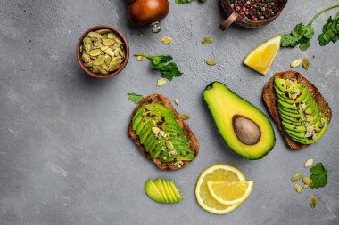 Taze yeşil Avokado sandviç çavdar ekmeği, kabak tohumu, tuz ve biber. Vejetaryen yemeği. Bitki temelli diyet. Temiz yemek. Üst Manzara. Boşluğu kopyala,