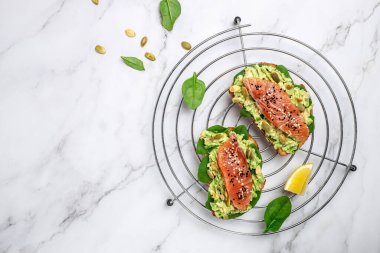 Avokadoo, somon ve ıspanak, fındık ve ayçekirdeği ile tost. Sağlıklı, temiz yemek. Vejetaryen ya da glütensiz diyet. Üst görünüm, boşluk kopyala.