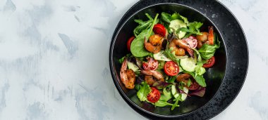 Füme karidesli deniz ürünleri salatası, kiraz domatesleri, salatalık ve karışık yapraklar. Sağlıklı beslenme konsepti. Detoks diyeti. Vejetaryen yemeği. Kilo kaybı, üst görünüm.