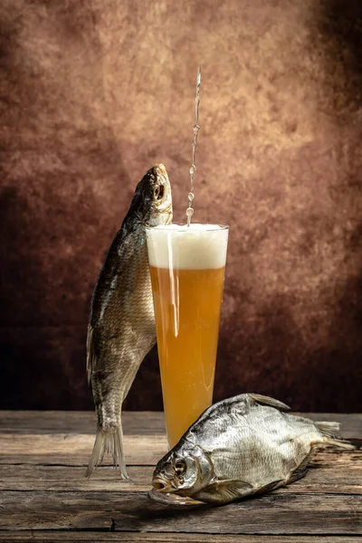 Glasses of beer and dried fish on a wooden table. Beer brewery concept. Snack for beer dried smelts. Beer background,