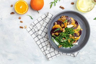 Roka, portakal ve cevizli sağlıklı pancar salatası. Temiz yemek, diyet, vejetaryen yemek konsepti. afiş, menü, metin için tarif yeri, üst görünüm.
