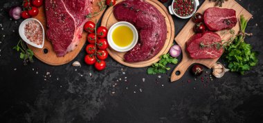 Arka planda pişmeye hazır baharatlı taze çiğ biftek seti. Uzun afiş biçimi. en üstteki görünüm.