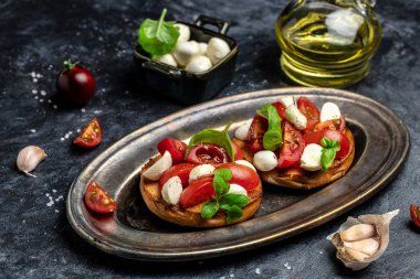 Kiraz domatesli sandviç, mini mozzarella, taze fesleğen yaprağı, ekmek üstü caprese, geleneksel İtalyan aperatifi veya aperatifi, antipasto. afiş, menü, metin için tarif yeri, üst görünüm.