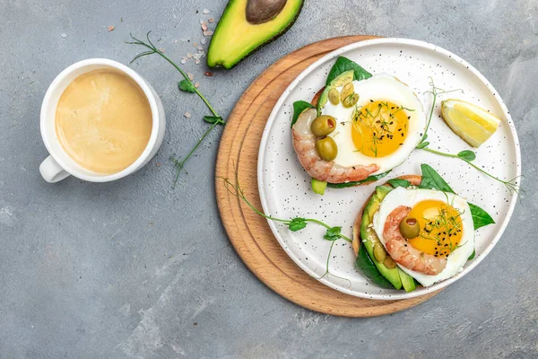 Ekmek, yumurta, ıspanak, avokado, karides ve gri arka planda bir fincan kahve ile tost yapın. Ketogenik kahvaltı. Süper yiyecek konsepti. Sağlıklı, temiz yemek. Üst görünüm,