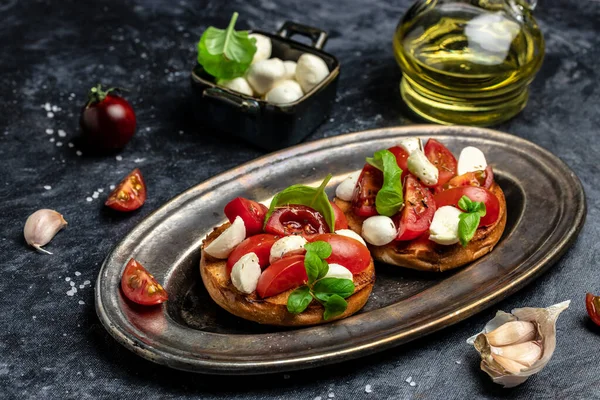 Kiraz domatesli sandviç, mini mozzarella, taze fesleğen yaprağı, ekmek üstü caprese, geleneksel İtalyan aperatifi veya aperatifi, antipasto. afiş, menü, metin için tarif yeri, üst görünüm.