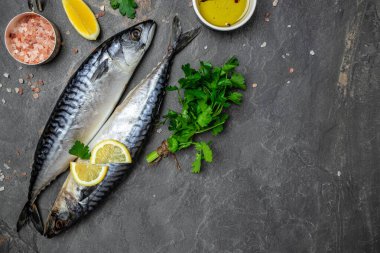 scomber, marinated mackerel or herring fish with salt, lemon and spices on a dark background. Seafood concept. top view,