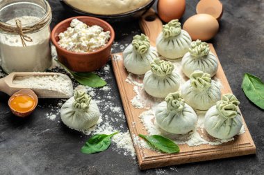 Peynirli ve ıspanaklı Gürcü hamur tatlısı. Çiğ, yarı bitmiş meyveli börekler. afiş, menü, metin için tarif yeri, üst görünüm.