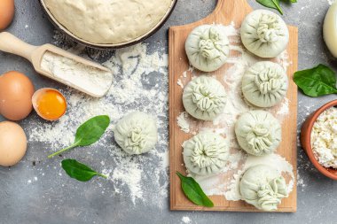 Peynir ve ıspanakla Khinkali pişirmek. Çiğ, yarı bitmiş meyveli börekler. Ulusal Gürcü mutfağı. metin için yer, üst görünüm.