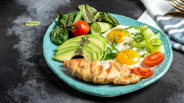 Ketogenik diyet kahvaltısı. Tavuk ızgara fileto salata taze domates, salatalık, yumurta ve avokado. Düşük karbonhidratlı yüksek yağlı kahvaltı..