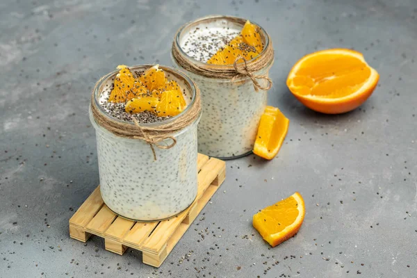 Narenciye ile süslenmiş camda laktozsuz yoğurt ile Chia Seed. Gri arka planda chia tohumlu yoğurt. sağlıklı süper yiyecekler. Sağlıklı yiyecekler. metin için yer.