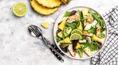 Ananaslı tavuk göğsü salatası, avokado, yeşil roket salatası, limon. Sağlıklı sulu yiyecekler. Uzun afiş biçimi. en üstteki görünüm,