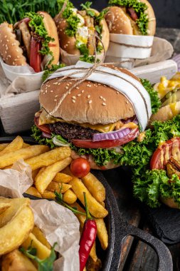 Ev yapımı lezzetli burger ve kızarmış tavuklu patates kızartması ile sosisli sandviç. Radyasyon Amerikan yemekleri. fast food. dikey görüntü. en üstteki görünüm.