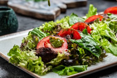 Tavuk ciğeri ve salata yaprakları, parmesan peyniri ve vişneli domates. Lezzetli dengeli gıda konsepti.