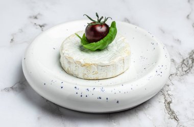 Fesleğen yapraklı Camembert peyniri. Yuvarlak brie peyniri ya da beyaz tabakta camambert peyniri. Yer mantarı peyniri. Yemek tarifi geçmişi. Kapat..