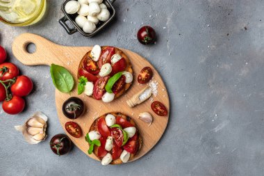 Kiraz domatesli sandviç, mini mozzarella, taze fesleğen yaprağı, ekmek üstü caprese, geleneksel İtalyan aperatifi veya aperatifi, antipasto. afiş, menü, metin için tarif yeri, üst görünüm.