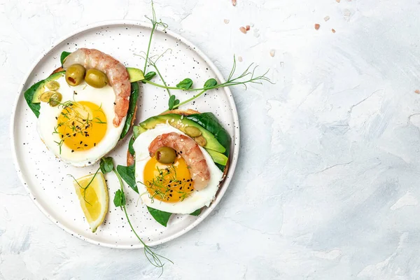 Tost ekmeği, yağda yumurta, ıspanak, avokado, karides ve ketogenik kahvaltı. Süper yiyecek konsepti. Sağlıklı, temiz yemek. Üst görünüm.