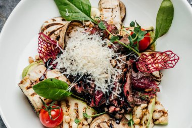 Izgara sebze, fındık, sos ve parmesanla dilimlenmiş biftek barbeküsü. İtalyan mutfağı konsepti. afiş, menü, metin için tarif yeri, üst görünüm.