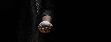 Beyaz takım elbiseli pasta şefi beyaz toz kaplı masaya top hamuru fırlatırken beyaz un havaya uçuyor. Doğa, İtalya, gıda, diyet ve biyoloji kavramı.