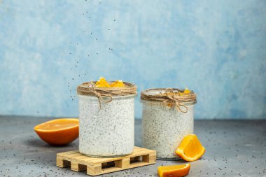 Narenciye ile süslenmiş camda laktozsuz yoğurt ile Chia Seed. Gri arka planda chia tohumlu yoğurt. sağlıklı süper yiyecekler. Sağlıklı yiyecekler. metin için yer.