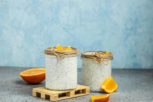 Narenciye ile süslenmiş camda laktozsuz yoğurt ile Chia Seed. Gri arka planda chia tohumlu yoğurt. sağlıklı süper yiyecekler. Sağlıklı yiyecekler. metin için yer.