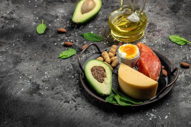 Keto diyet yemeği, somon, avokado, peynir, yumurta, ıspanak ve fındık. Ketojenik düşük karbonhidrat diyet konsepti. Sağlıklı yiyecekler seçimi için malzemeler, metin için yer, üst görünüm,
