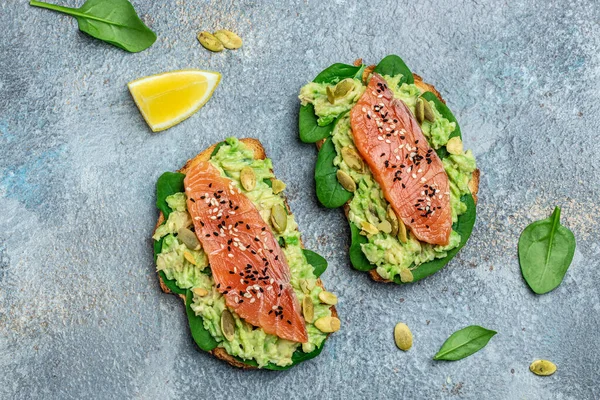 Avokadoo, somon ve ıspanak, fındık ve ayçekirdeği ile tost. Sağlıklı, temiz yemek. Vejetaryen ya da glütensiz diyet. Üst görünüm, boşluk kopyala.