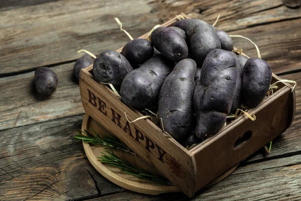 Raw purple sweet potato food . Fresh potatoes in an old sack on wooden background. Batata potato. vegan food ingredient. banner, menu, recipe place for text, top view.