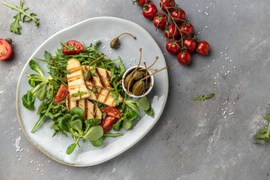 Gri tabakta ızgara Halloumi peynirli salata, Kıbrıs peyniri. en üstteki görünüm.