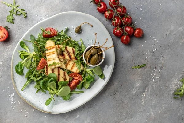 Gri tabakta ızgara Halloumi peynirli salata, Kıbrıs peyniri. en üstteki görünüm.