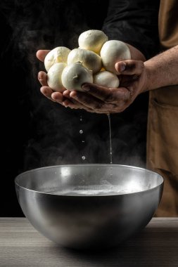 Ev yapımı peynir üreticisi taze biyo sütle el yapımı mozzarella üretir. Mozzarella yapma süreci. İtalyan sert peynirli silano veya peynirci ellerinde caciocavallo..