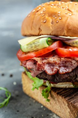 Jambonlu hamburger, peynir, pastırma, salata ve sebze. Büyük hamburger, Amerikan fast food. dikey görüntü. Üst Manzara. metin için yer,