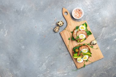 Ekmek, yumurta, ıspanak, avokado, gri arka planda karides, ketogenik kahvaltı. Süper yiyecek konsepti. Sağlıklı beslenme. Üst görünüm.