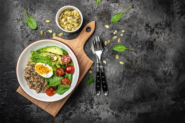 İçinde avokado, yumurta, domates, ıspanak ve ay çekirdeği olan kinoa budha kasesi. Ev yapımı yemek. Sağlıklı, temiz yemek. Vegan ya da glütensiz diyet, metin yeri, üst görünüm,