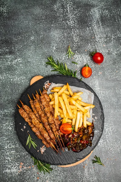 Grilled meat skewers, shish kebab with onion and sweet pepper. Georgian cuisine. hearty lunch or dinner, vertical image. top view. place for text.