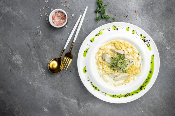 Tavuklu makarna, kremalı soslu Fettuccine Alfredo, tavuklu, parmesanlı beyaz tabak. İtalyan mutfağı. Restoran menüsü, diyet, yemek kitabı tarifi üst görünümü.