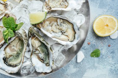 Restoranda şampanyayla istiridye açtık. Limonlu, buzlu taze istiridye. afiş, menü, metin için tarif yeri, üst görünüm.