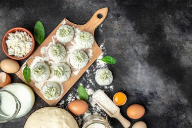 Peynirli ve ıspanaklı Khinkali. Çiğ, yarı bitmiş meyveli börekler. Khinkali pişirmek. Ulusal Gürcü mutfağı. afiş, menü, metin için tarif yeri, üst görünüm.