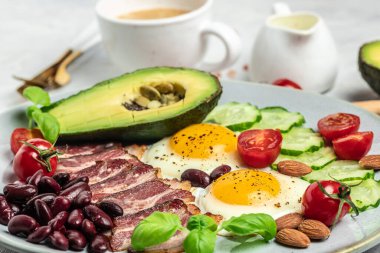 Avokado, sahanda yumurta, pastırma ve fasulyeyle Keto kahvaltısı. Paleo Keto kahvaltı diyeti öğle yemeği. Sağlıklı besleyici paleo keto kahvaltı konsepti. Yemek tarifi geçmişi. Kapat.,
