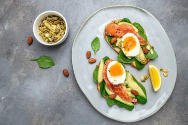 Avokadoo, somon ve ıspanak, fındık ve ayçekirdeği ile tost. Sağlıklı, temiz yemek. Vejetaryen ya da glütensiz diyet. Üst görünüm, boşluk kopyala.
