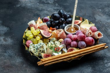 Peynir tabağı. Peynir aperatifleri prosciutto, bal, fındık ve metal tepside üzüm.,