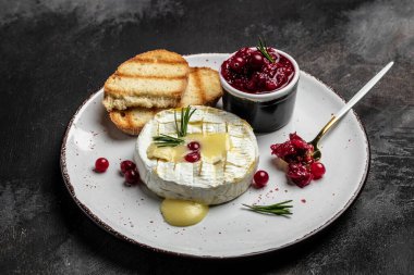 Koyu masada, kızılcık, fesleğen ve biberiye ile pişirilmiş peynirli camembert peyniri. Fransız mutfağı. metin için yer, üst görünüm.