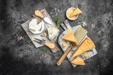 Parmesan peyniri. Koyu arkaplanda bıçak olan farklı peynir türleri. Cheeses set dor blu chedar camamber brie. metin için yer, üst görünüm.