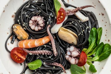 Deniz ürünleri ahtapotlu mürekkep balığı spagettisi, hafif arka planda midye ve karides. afiş, menü, metin için tarif yeri, üst görünüm