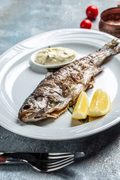 Grilled sea bass, Grilled Fresh sea bass. Mediterranean fish, baked with herbs and lemon. vertical image. top view. place for text,