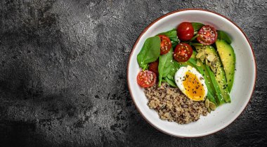 İçinde avokado, yumurta, domates, ıspanak ve ayçiçeği tohumları olan kinoa budha kasesi. Ev yapımı yemek. Sağlıklı, temiz yemek. Vejetaryen ya da glütensiz diyet, uzun pankart formatı. en üstteki görünüm.