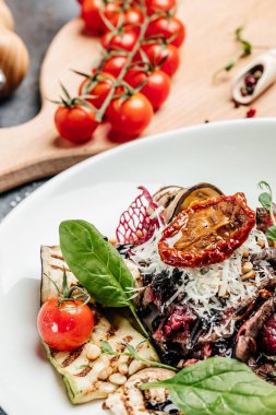 Izgara sebze, fındık, sos ve parmesanla dilimlenmiş biftek barbeküsü. İtalyan mutfağı konsepti. afiş, menü, metin için tarif yeri, üst görünüm.