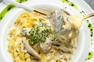 Tavuklu makarna, kremalı soslu Fettuccine Alfredo, tavuklu, parmesanlı beyaz tabak. İtalyan mutfağı. Restoran menüsü, diyet, yemek kitabı tarifi üst görünümü.