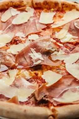 Jambonlu pizza, parmesan peyniri, İtalyan mutfağı, dikey görüntü. Üst Manzara. Yemek tarifi geçmişi. Kapat..